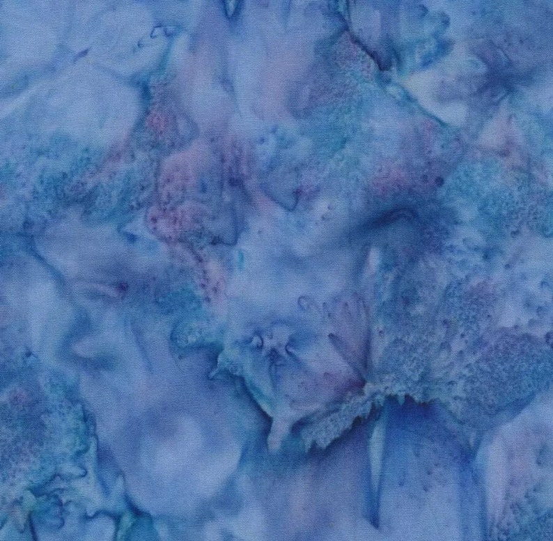 May include: A seamless fabric pattern in shades of blue and purple, resembling a watercolour design. The pattern has a mottled appearance with soft, blended edges, creating a textured, artistic look. The fabric is likely cotton or a similar material.