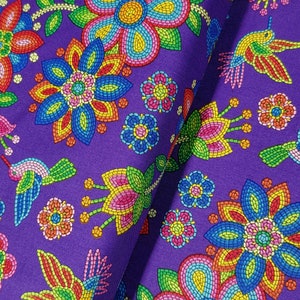May include: Purple fabric with a repeating pattern of colorful flowers and hummingbirds. The flowers are made of small, colorful beads and the hummingbirds are outlined in black.