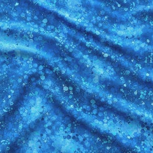 May include: A blue fabric featuring a mottled, abstract pattern of various shades of blue, ranging from deep navy to bright cyan. The design consists of numerous small, circular, and irregular splattered spots that create a textured, layered appearance.