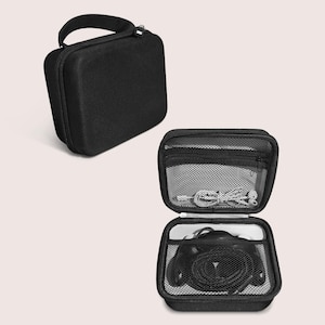 May include: Two black zippered cases, one closed and one open, displayed against a light background. The open case reveals a mesh interior with a zipper pocket and a pair of headphones and cables. The closed case has a handle.