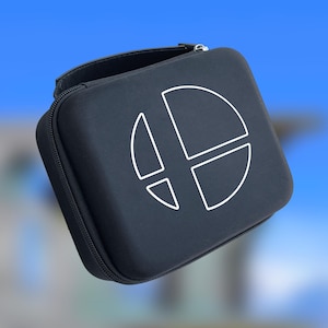 May include: A black, square carrying case with a white graphic on the front. The graphic is a stylized symbol. The case has a zipper closure and a small handle. The background is a blurred gradient of blue and white.