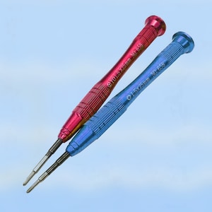 May include: Two screwdrivers, one red and one blue, with metal handles and black tips. The red screwdriver has the text "Ø1.0 x 5.5mm No.658" printed on the side. The blue screwdriver has the text "Ø1.5x2.5mm No.658" printed on the side.