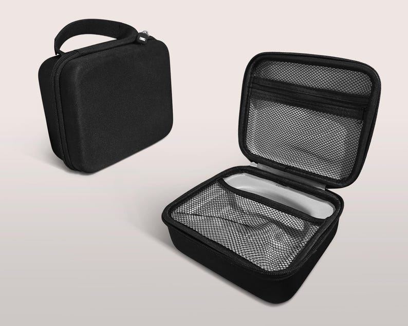 May include: Black, rectangular carrying case with a handle and zipper closure. The case is shown closed and open, revealing a mesh pocket and interior compartment. The open case has a gray interior.