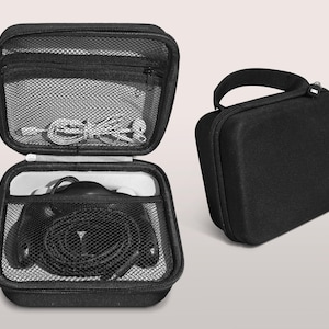 May include: Black zippered carrying case, open to reveal headphones and cables. The case has a mesh pocket on the top and a handle on the side. A second, closed black case is also shown.