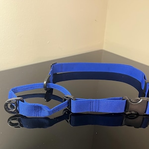 Puede incluir: Dos collares azules para perros con hebillas de plástico negro y anillos metálicos. Los collares están hechos de tela tejida y son ajustables. Un collar es más grande que el otro.