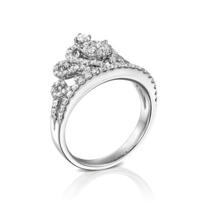 May include: A silver ring with a delicate, intricate design featuring a cluster of small diamonds. The ring is set with a larger diamond in the center, surrounded by smaller diamonds.