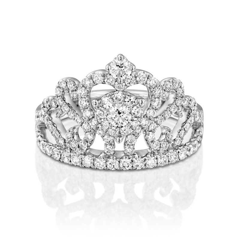 May include: A silver ring with a crown design featuring a large round diamond surrounded by smaller diamonds.