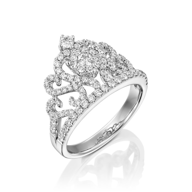 May include: A silver ring with a crown design set with small diamonds.