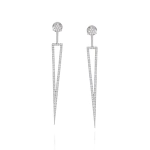 Könnte beinhalten: Ein Paar silberne Ohrringe mit geometrischem Design. Jeder Ohrring hat eine lange, spitze Dreiecksform mit einem kleineren Dreieck oben. Die Dreiecke sind mit kleinen, klaren Diamanten umrandet.