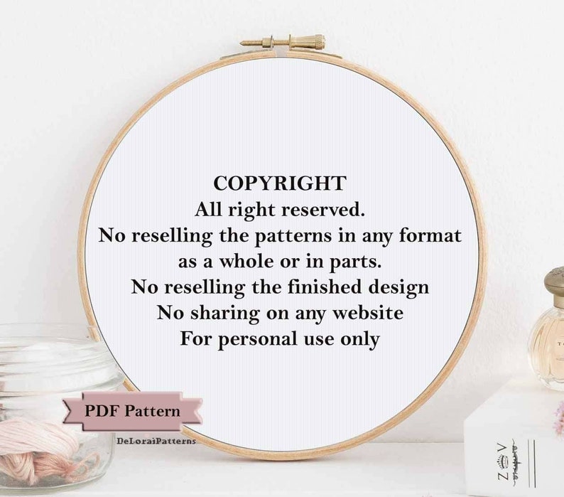 May include: A white embroidery hoop with black text that reads "COPYRIGHT All right reserved. No reselling the patterns in any format as a whole or in parts. No reselling the finished design No sharing on any website For personal use only PDF Pattern DeLorai Patterns"