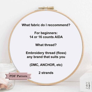 May include: A close-up of a wooden embroidery hoop with instructions for beginners on what fabric and thread to use for embroidery. The text reads: "What fabric do I recommend? For beginners: 14 or 16 counts AIDA. What thread? Embroidery thread (floss) any brand that suits you (DMC, ANCHOR, etc) 2 strands. PDF Pattern."