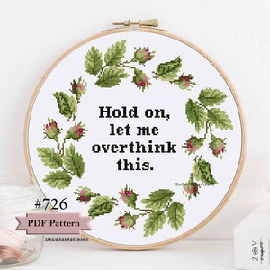 Puede incluir: Patrón de punto de cruz con una corona de hojas verdes y flores rosas. El texto en el centro dice "Hold on, let me overthink this."