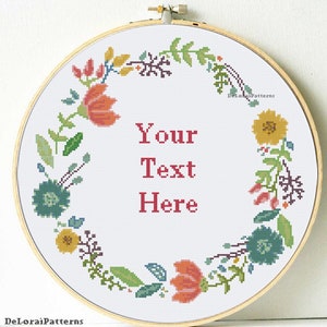 Könnte beinhalten: Ein weißer Stickrahmen mit einem floralen Kranzdesign in Rot-, Gelb-, Grün- und Blautönen. Der Text "Your Text Here" befindet sich in der Mitte des Rahmens.