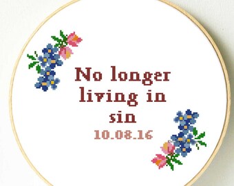 Può includere: Un telaio da ricamo a punto croce con la scritta "No longer living in sin" e la data 10.08.16. Il design include accenti floreali blu e rosa. Il ricamo è ambientato in un telaio di legno.