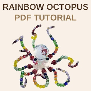 Könnte beinhalten: Eine perlenbesetzte Oktopus-Figur mit einem großen, klaren, facettierten Kristallkopf und acht Tentakeln aus mehrfarbigen Glasperlen in Rot, Orange, Gelb, Grün, Blau und Violett. Der Text RAINBOW OCTOPUS PDF TUTORIAL steht über der Figur.