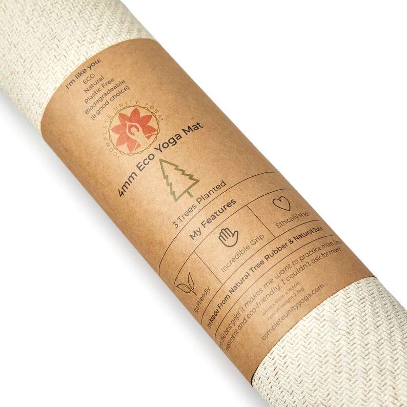 May include: A brown paper tube with a label that reads "4mm Eco Yoga Mat" and lists features such as "Incredible Grip" and "Made From Natural Tree Rubber & Natural Latex". The label also states that 3 trees are planted for each mat purchased. The tube is rolled up and the end of the mat is visible.