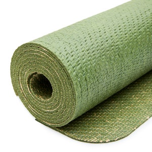 May include: A rolled up green yoga mat with a textured surface. The mat is partially unrolled, revealing a green and brown patterned underside.