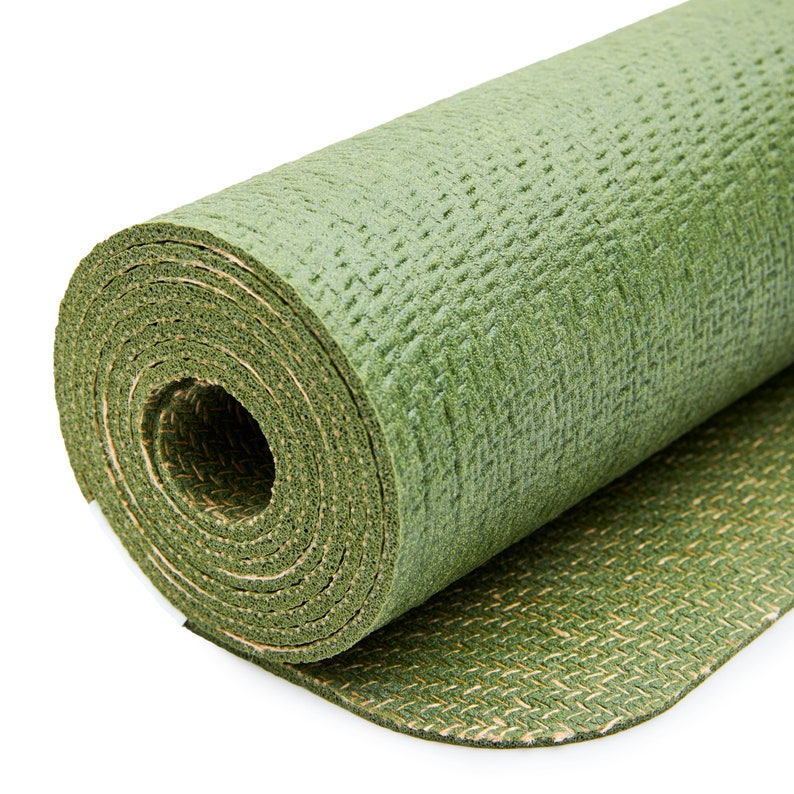 May include: A rolled up green yoga mat with a textured surface. The mat is partially unrolled, revealing a green and brown patterned underside.
