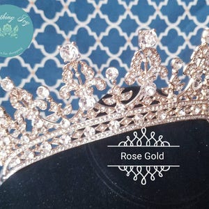 Puede incluir: Una corona de oro rosa con diamantes de imitaci&oacute;n transparentes. La corona est&aacute; sobre un fondo de terciopelo negro.