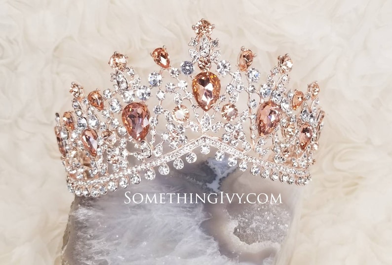 Puede incluir: Una tiara de oro rosa con diamantes de imitaci&oacute;n transparentes y melocot&oacute;n. La tiara tiene un dise&ntilde;o delicado e intrincado y es perfecta para una ocasi&oacute;n especial.