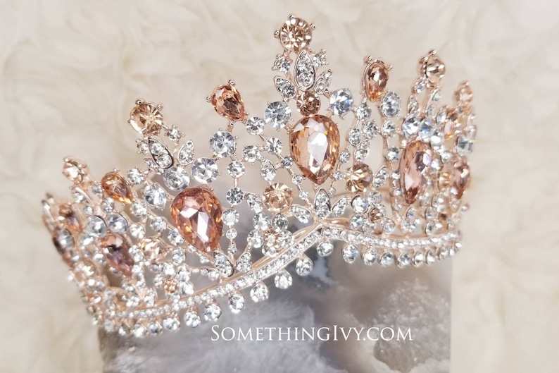 Puede incluir: Una tiara de oro rosa con diamantes de imitaci&oacute;n transparentes y color champ&aacute;n. La tiara tiene un delicado dise&ntilde;o floral y est&aacute; adornada con piedras en forma de l&aacute;grima.
