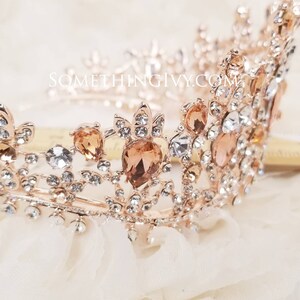 Puede incluir: Una tiara de oro rosa con diamantes de imitaci&oacute;n transparentes y &aacute;mbar. La tiara tiene un delicado dise&ntilde;o floral y es perfecta para una boda u ocasi&oacute;n especial.