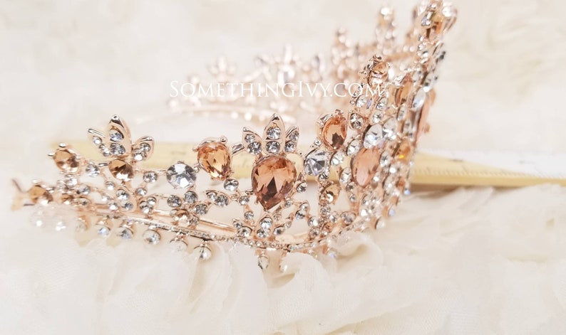 Puede incluir: Una tiara de oro rosa con diamantes de imitaci&oacute;n transparentes y &aacute;mbar. La tiara tiene un delicado dise&ntilde;o floral y es perfecta para una boda u ocasi&oacute;n especial.