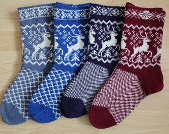 May include: Four pairs of knitted socks with a white reindeer pattern on a blue, navy, and red background.