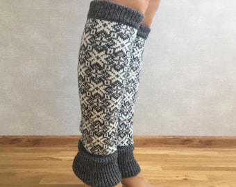 May include: Gray and white knitted leg warmers with a geometric pattern. The leg warmers are folded down at the top, revealing a gray cuff.