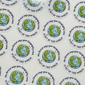 May include: A set of round stickers with a cartoon illustration of a smiling earth hugging itself. The text on the stickers reads "Mrs. Brown says your Geography work is out of this world!"
