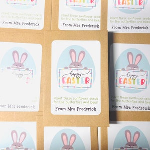 May include: Six brown paper seed packets with colourful bunny illustrations and the text "Happy Easter" on each. The packets have instructions to plant the seeds for butterflies and bees. Each packet is signed "From Mrs Frederick."