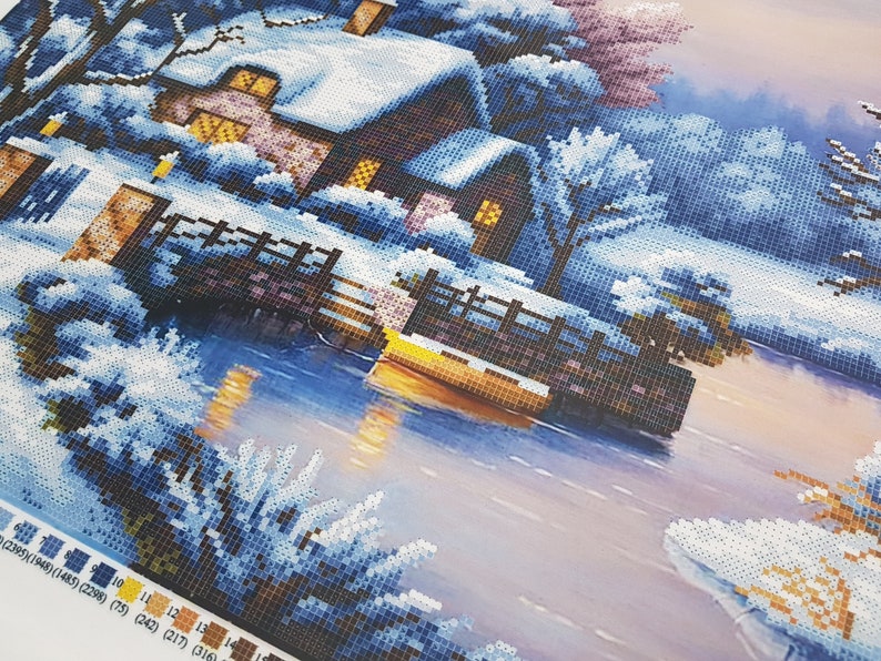 May include: A winter scene with a small cottage covered in snow, a wooden bridge over a frozen lake, and trees covered in snow. The sky is a light blue with a hint of pink.