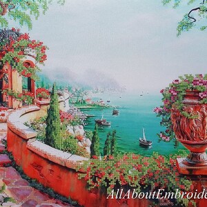 Puede incluir: Una pintura de un jard&iacute;n mediterr&aacute;neo con un patio de piedra, un cenador y una gran maceta de terracota llena de flores rosas. La vista desde el patio se extiende sobre un mar azul turquesa con veleros en la distancia.