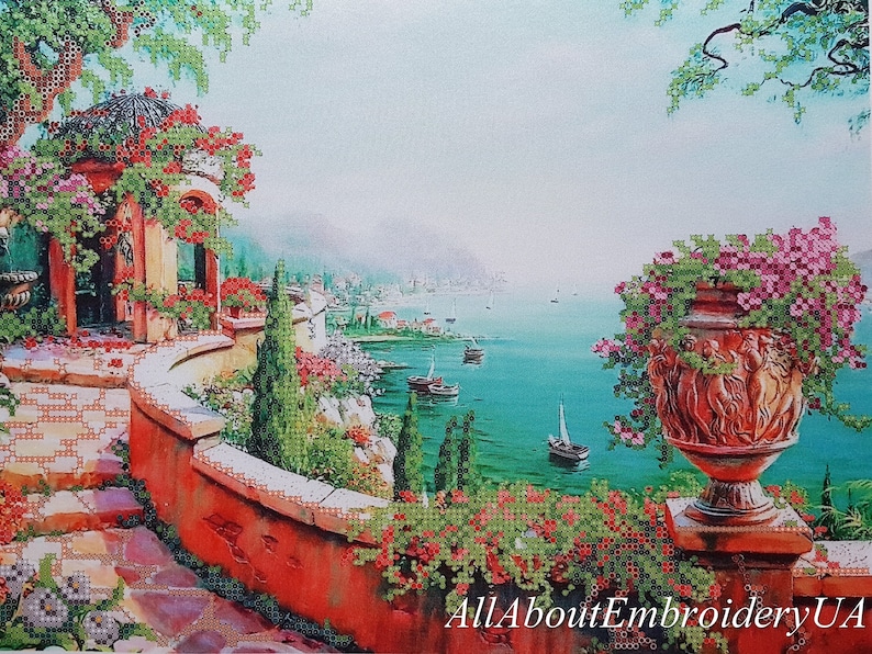 Puede incluir: Una pintura de un jard&iacute;n mediterr&aacute;neo con un patio de piedra, un cenador y una gran maceta de terracota llena de flores rosas. La vista desde el patio se extiende sobre un mar azul turquesa con veleros en la distancia.