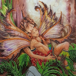 May include: A beaded embroidery artwork depicting two fairies embracing in a forest setting. The fairies have intricate wings and are surrounded by lush greenery. The artwork is framed and has a watercolor-like background.