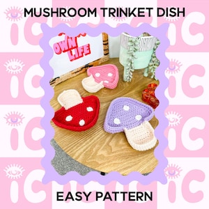 May include: Handmade crochet mushroom trinket dishes in red, pink, and purple with white detailing. The image includes the text "Mushroom Trinket Dish" and "Easy Pattern". A decorative sign with the text "Own Life" is also visible.