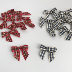 May include: A collection of red and white plaid and blue and white gingham ribbon bows. The bows are arranged in two groups, with the plaid bows on the left and the gingham bows on the right.