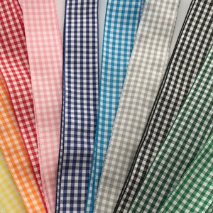 May include: Assortment of gingham ribbon in various colours, including yellow, orange, red, pink, blue, grey, black, and green.