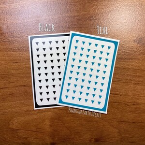 Pu&ograve; includere: Due fogli di carta adesiva con un motivo a triangolo. Un foglio &egrave; nero con triangoli neri e l'altro foglio &egrave; turchese con triangoli turchesi. Il testo "BLACK" e "TEAL" &egrave; stampato sopra ogni foglio. Il testo "PHANTOM EARTH DECALS" &egrave; stampato sotto i fogli.