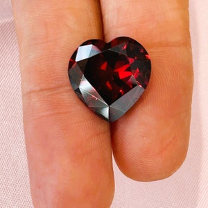 Może przedstawiać: Czerwony, fasetowany kamień szlachetny w kształcie serca.