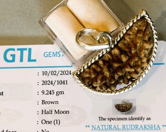 May include: A half-moon shaped natural brown Rudraksha seed pendant set in a twisted silver metal frame. The pendant is displayed with a GTL certification card listing a weight of 9.245 gm and identifying the specimen as a natural Rudraksha.