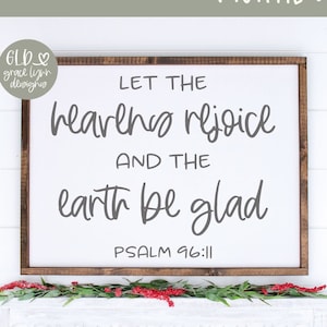 May include: A digital cut file design featuring the text "Let the heavens rejoice and the earth be glad, Psalm 96:11". The design is shown on a white sign with a wooden frame, and a white shelf with greenery and red berries.