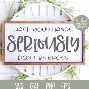 May include: A rectangular wooden sign with the text "WASH YOUR HANDS SERIOUSLY DON'T BE GROSS" in gray lettering. The sign is surrounded by a white decorative element and greenery. The bottom of the sign has the text "SVG - DXF - PNG - EPS".