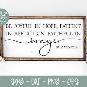 May include: A wooden sign with a white background and brown frame. The sign features a black text quote: "Be joyful in hope, patient in affliction, faithful in prayer." The quote is attributed to Romans 12:12.