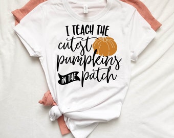 May include: White t-shirt with black text that reads "I teach the cutest pumpkins in the patch" with an orange pumpkin graphic.