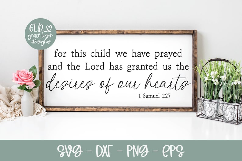 May include: A wooden sign with a white background and brown frame. The sign features a Bible verse from 1 Samuel 1:27, which reads "for this child we have prayed and the Lord has granted us the desires of our hearts".