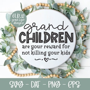 May include: A white round wooden sign with the text "grand CHILDREN are your reward for not killing your kids" in black lettering. The sign is surrounded by a garland of green leaves and wooden beads.