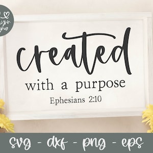 May include: White framed sign with black text that reads "created with a purpose Ephesians 2:10".