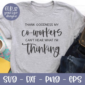 May include: A gray t-shirt with the text "THANK GOODNESS MY co-workers CAN'T HEAR WHAT I'M Thinking". The shirt is laying on a white surface with a pair of blue jeans and a brown baseball cap with the text "be kind." on it.