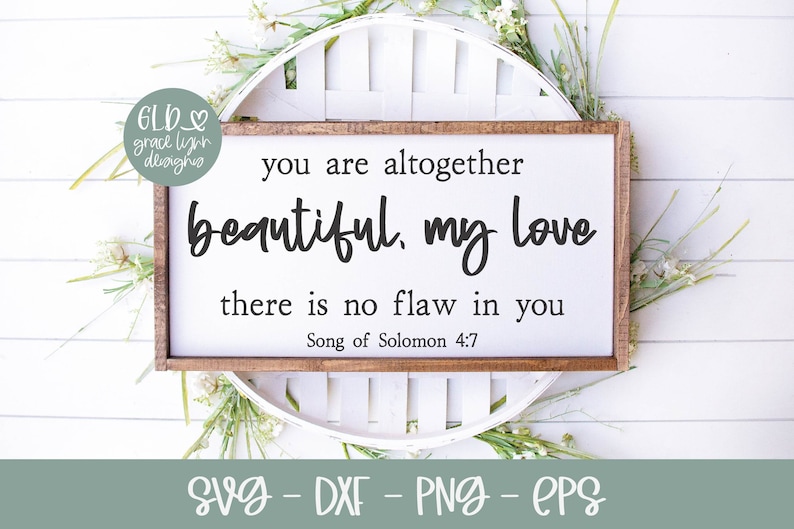 May include: A wooden sign with the text "you are altogether beautiful, my love there is no flaw in you Song of Solomon 4:7" in black lettering. The sign is sitting on a white surface with green plants.